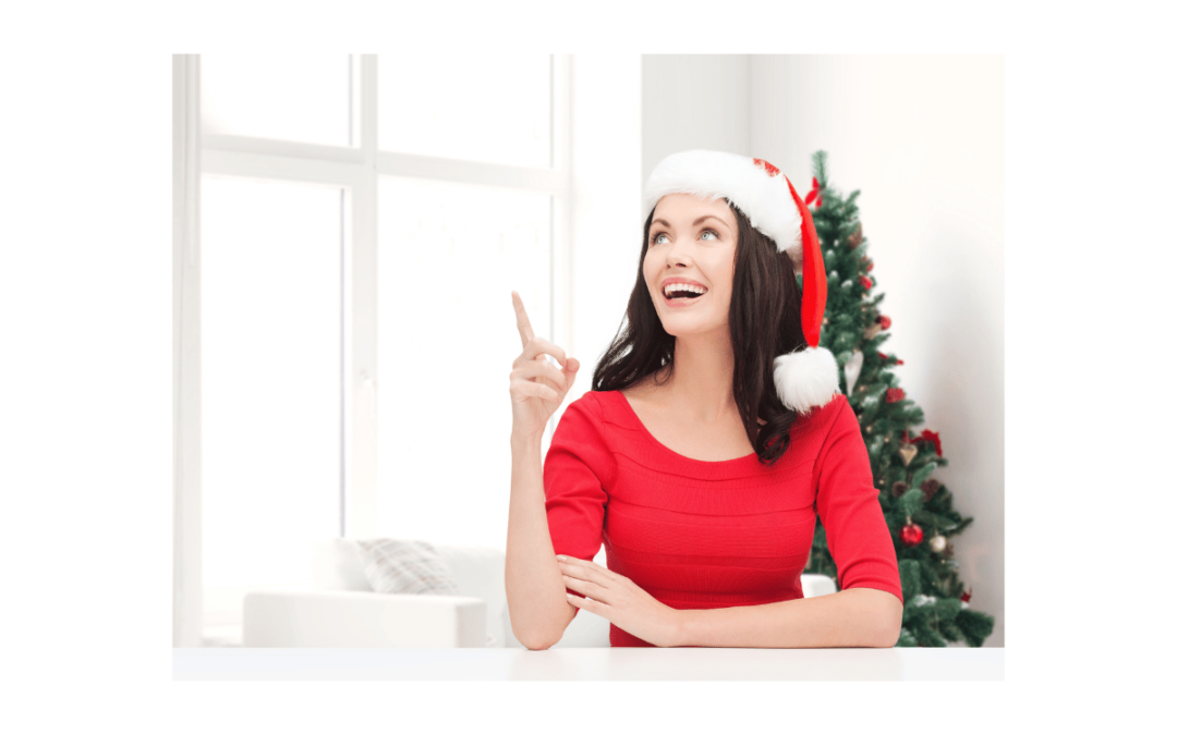 woman wearing santa hat pointing up and smiling